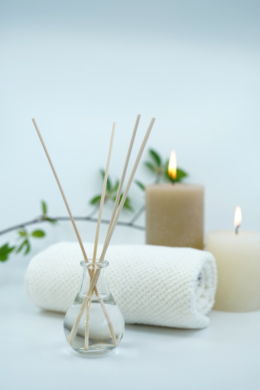 Difusor de aromaterapia con velas encendidas y toalla enrollada, ambiente cálido.